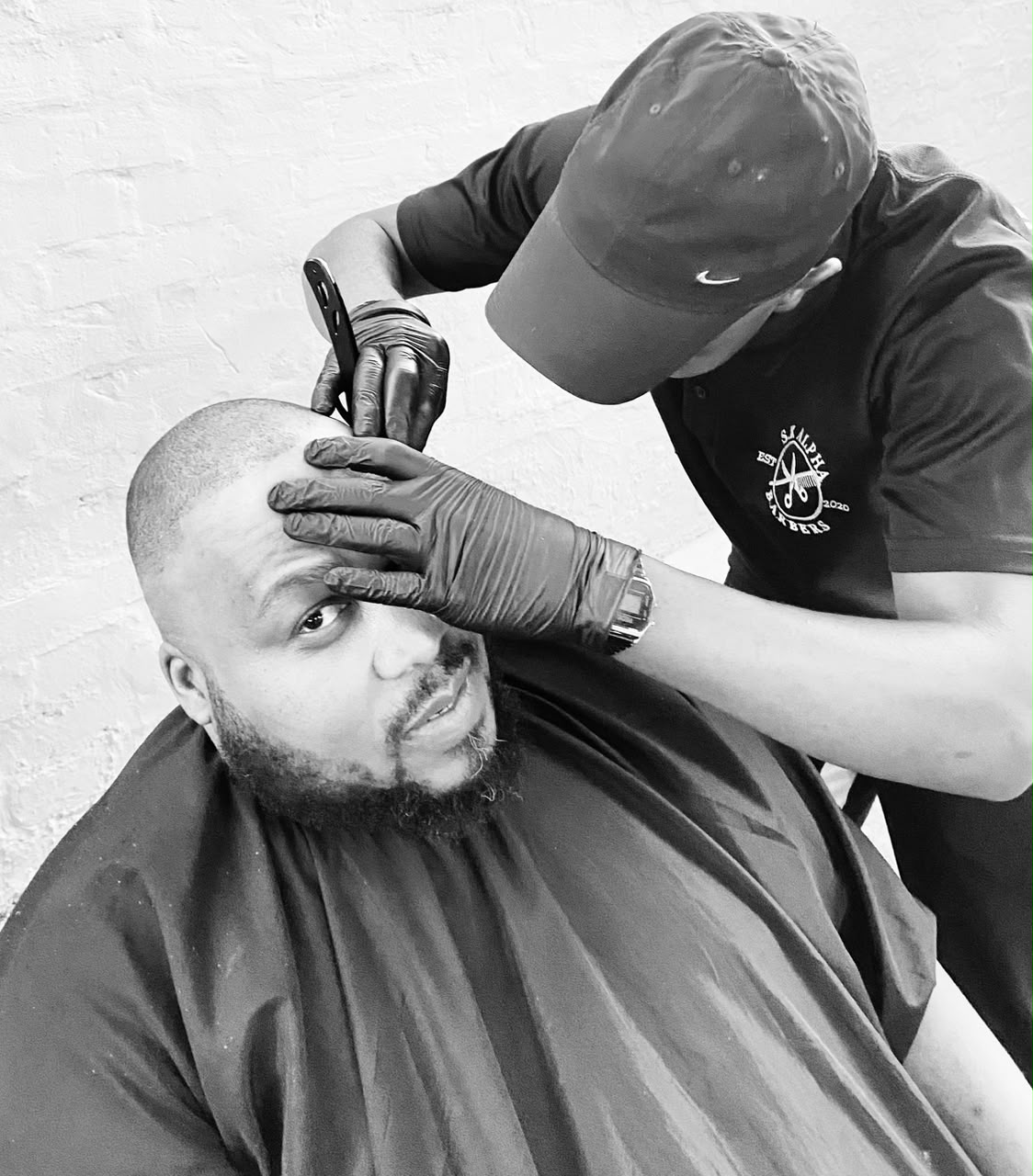 S.K Alpha barber giving a precision cut