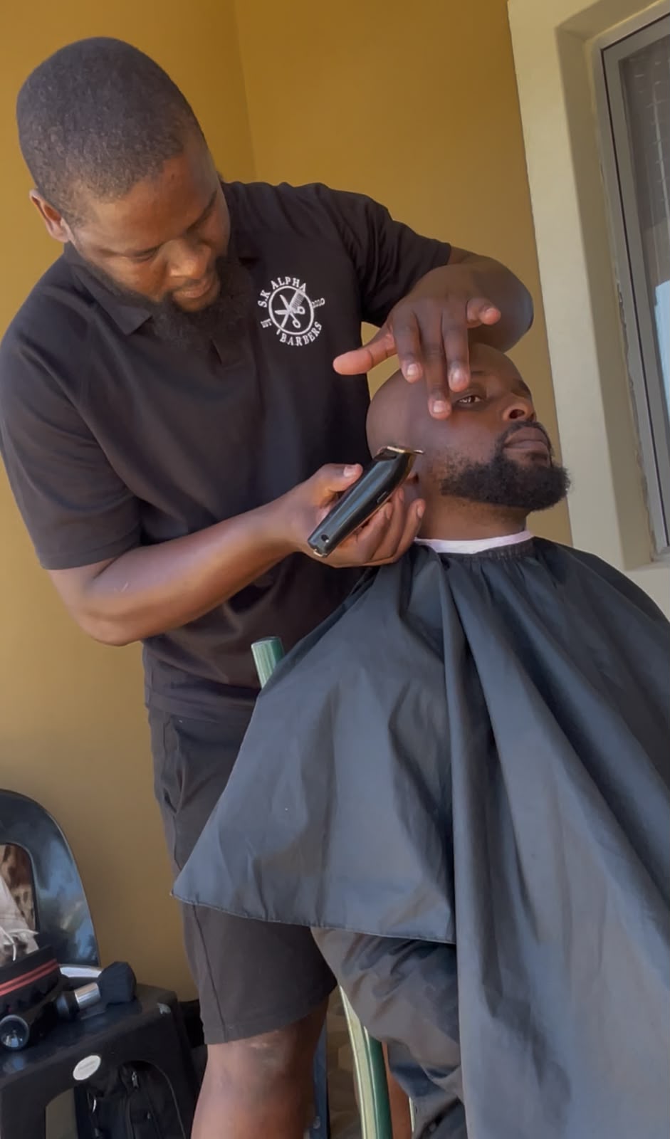 S.K Alpha barber giving a precision cut