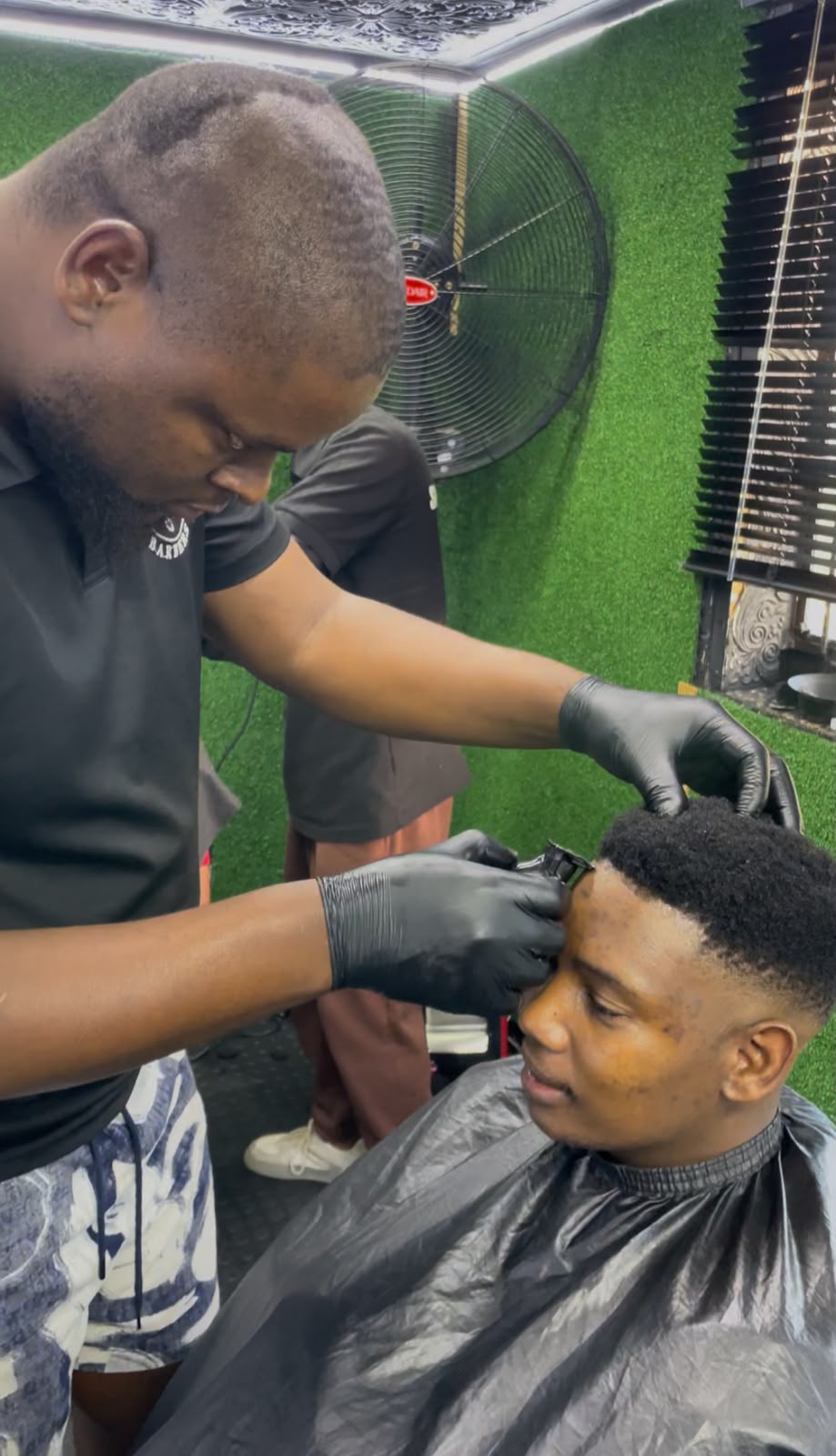 Barber shaping a fade with clippers